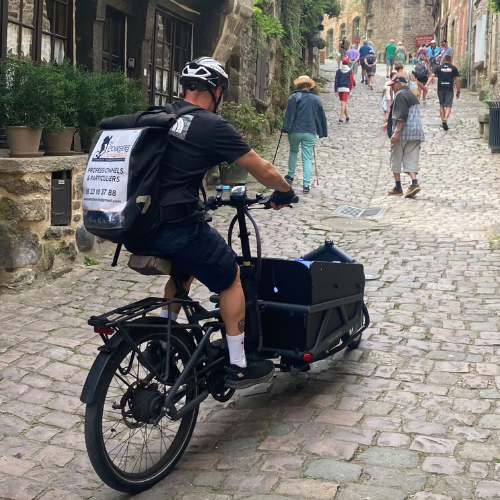 Jimmy Labbé, cyclo-logisticien en pleine livraison dans la rue pentue du Jerzual à Dinan